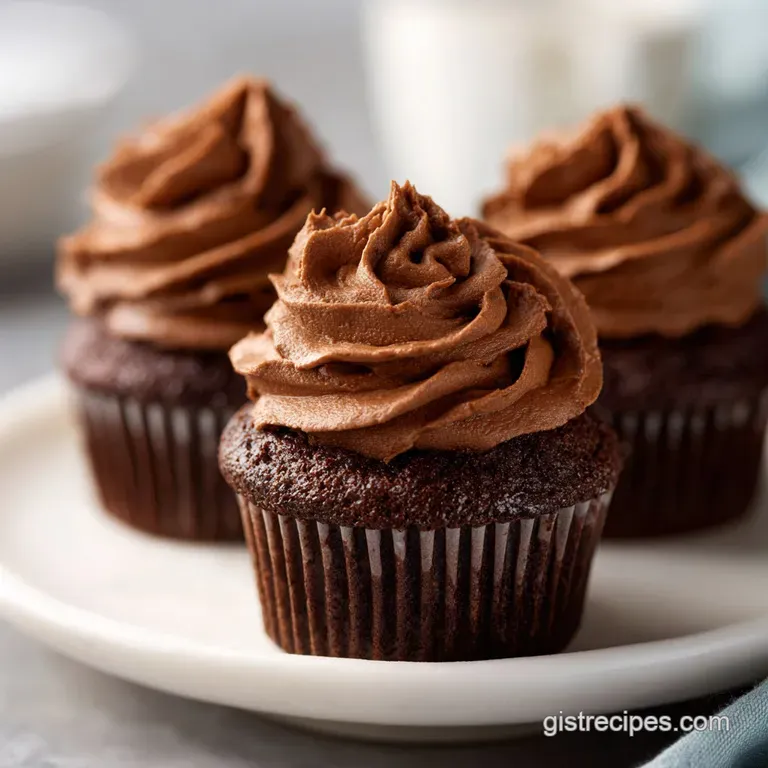 A single chocolate cupcake with peanut butter frosting on a dessert plate, chocolate shavings nearby, showcasing a delicio...